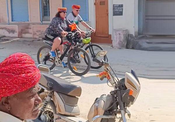 Cycling through villages in Rajasthan, with traditional Rajasthani houses and the simple yet vibrant rural life offering an authentic cultural experience.